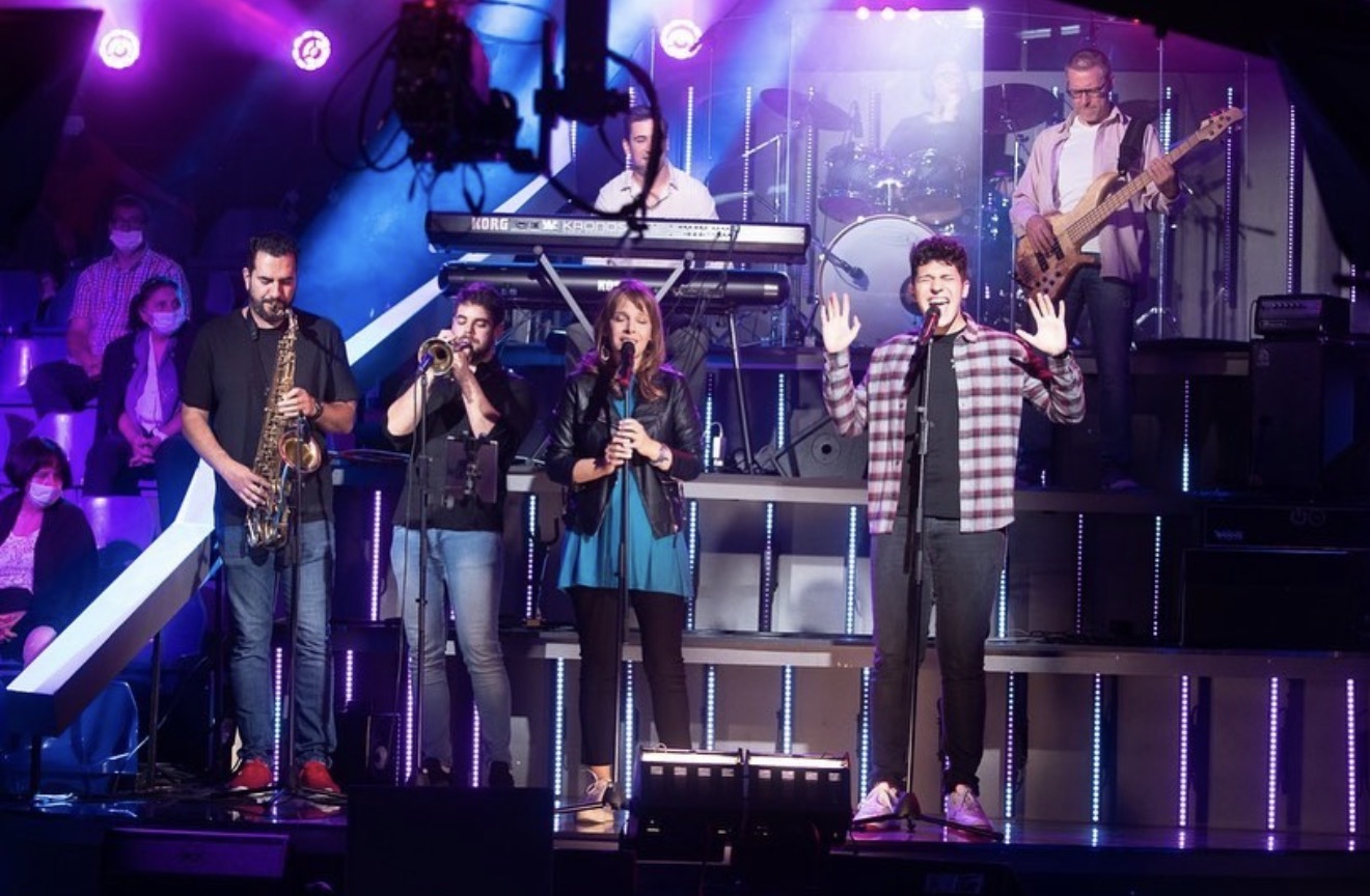 ILIJA singing with a full horn section and band on a televised music stage