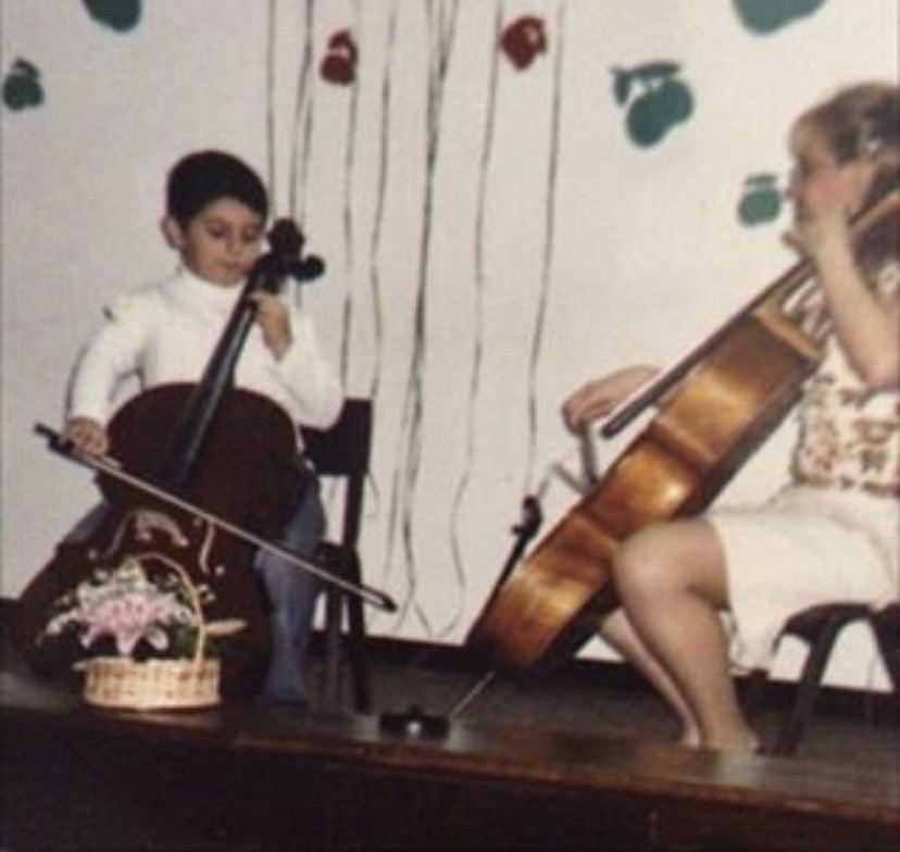 A young ILIJA playing cello at a childhood recital