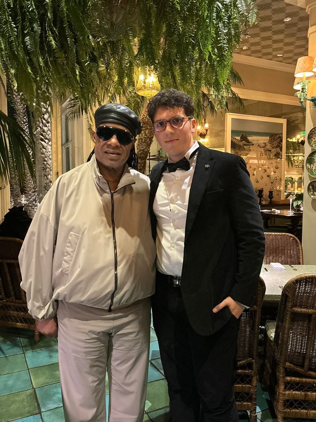 ILIJA in a black tuxedo standing beside Stevie Wonder