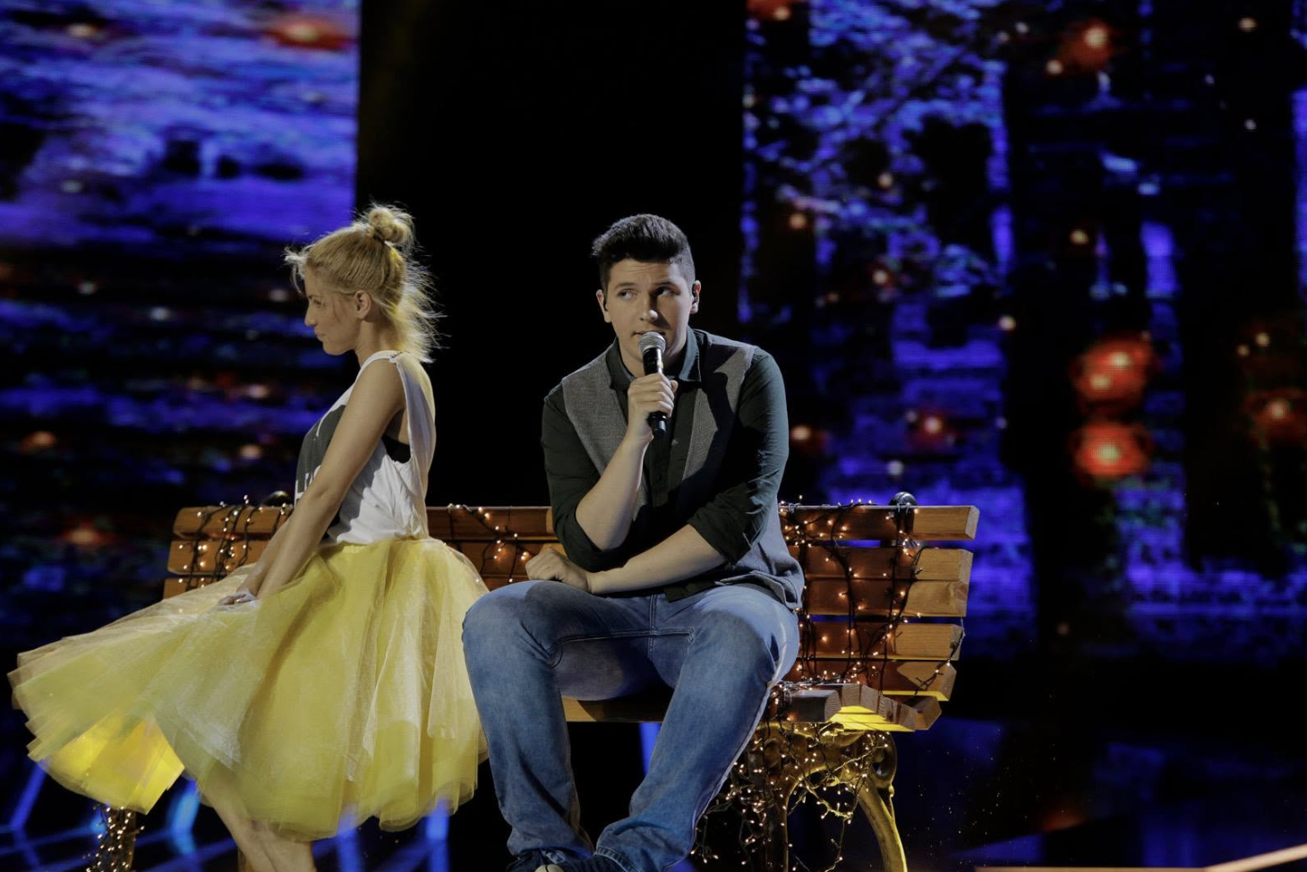 ILIJA performing on a bench during a live X Factor Adria show