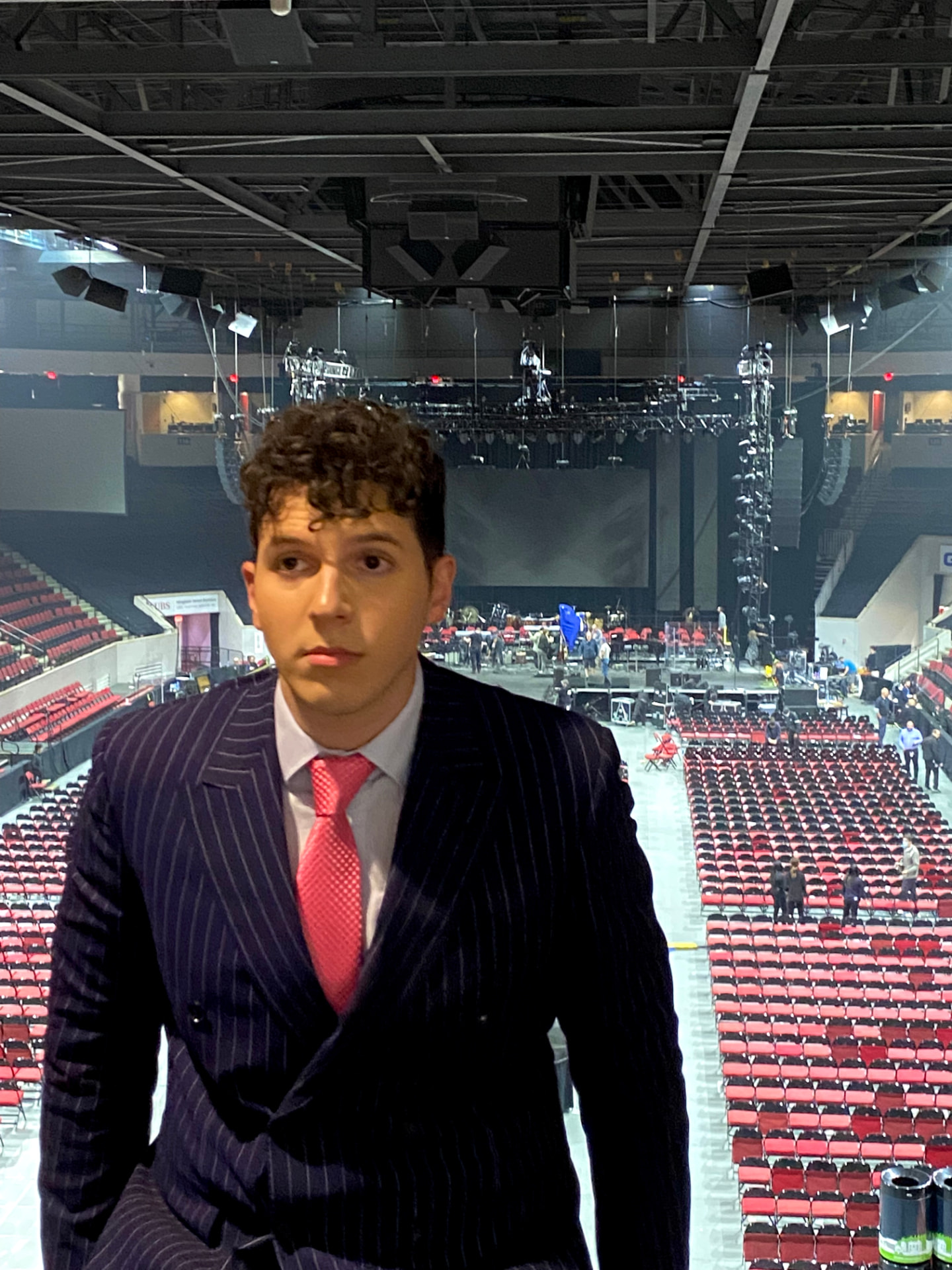 ILIJA in a navy pinstripe suit inside a large arena before a performance